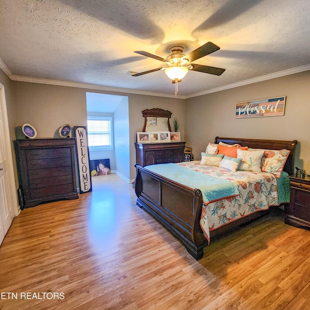 bedroom featuring ornamental molding, light wood-type flooring, a textured ceiling, and ceiling fan