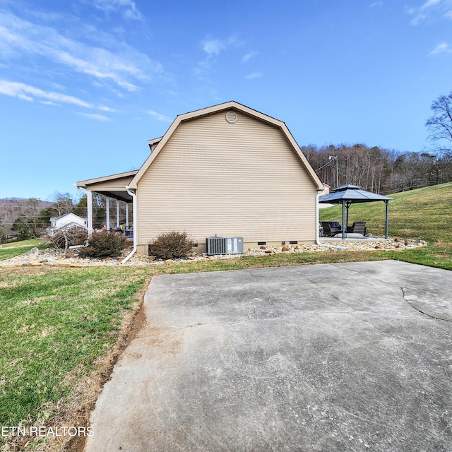 view of side of property with a gazebo, central AC unit, and a lawn