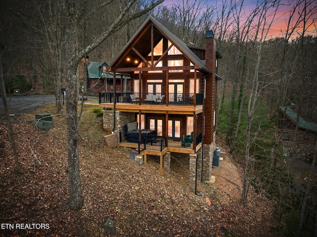 back house at dusk with a wooden deck