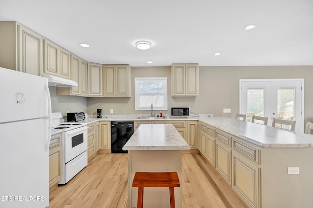 kitchen with white appliances, a center island, a breakfast bar area, and sink