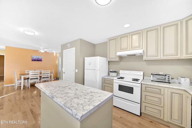 kitchen featuring cream cabinets, white appliances, light hardwood / wood-style floors, and a kitchen island