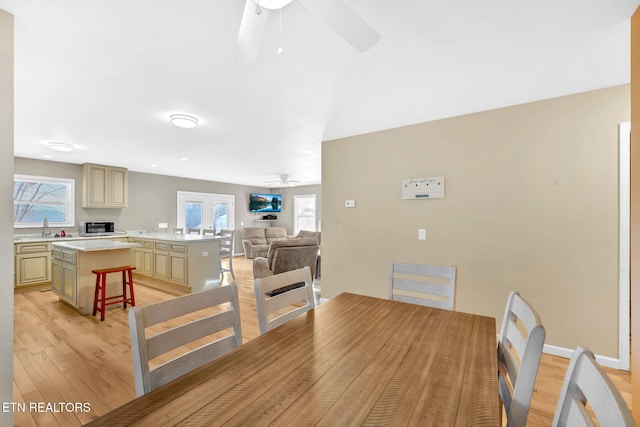 kitchen featuring a kitchen bar, french doors, sink, light hardwood / wood-style floors, and a kitchen island