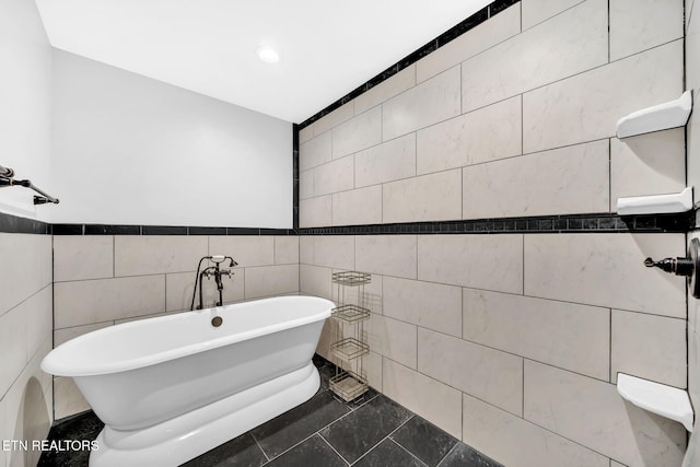 bathroom with a washtub, tile walls, and tile patterned flooring