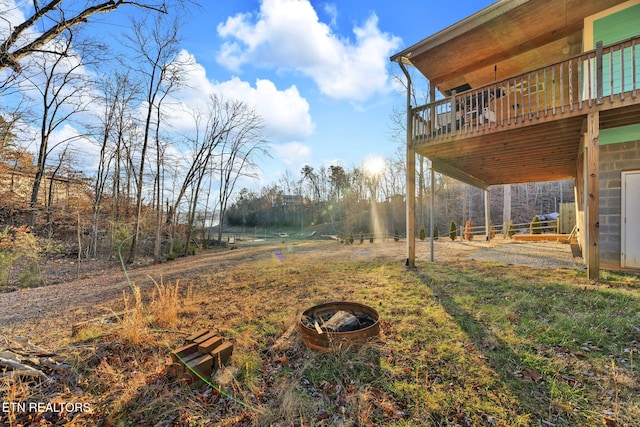 view of yard with an outdoor fire pit and a wooden deck