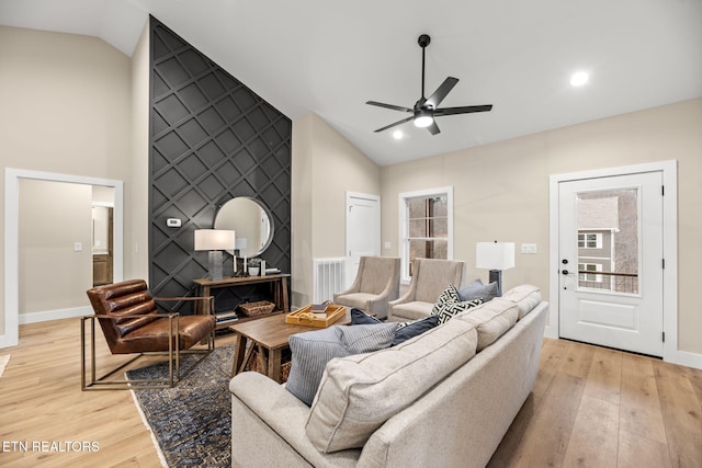 living room with vaulted ceiling, ceiling fan, and light hardwood / wood-style floors