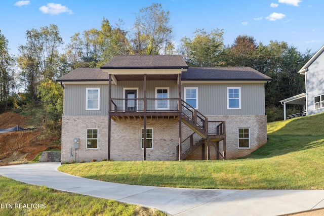 view of front of house with brick siding, stairway, and a front lawn