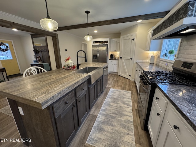 kitchen with sink, extractor fan, a kitchen island with sink, white cabinets, and appliances with stainless steel finishes