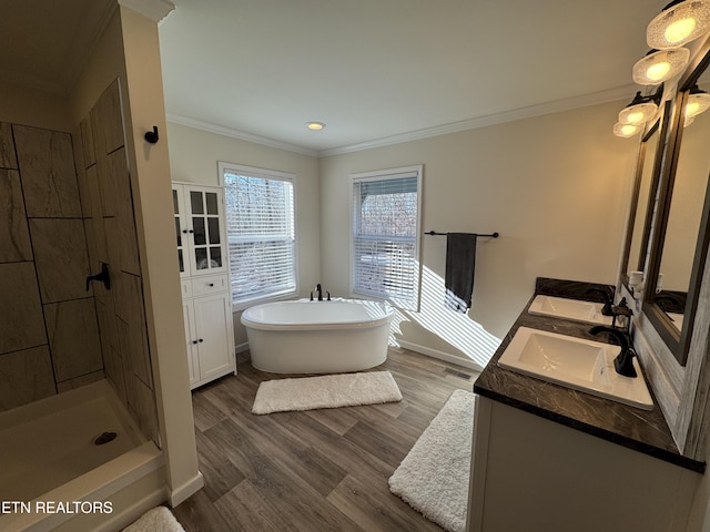 bathroom with plus walk in shower, vanity, wood-type flooring, and ornamental molding