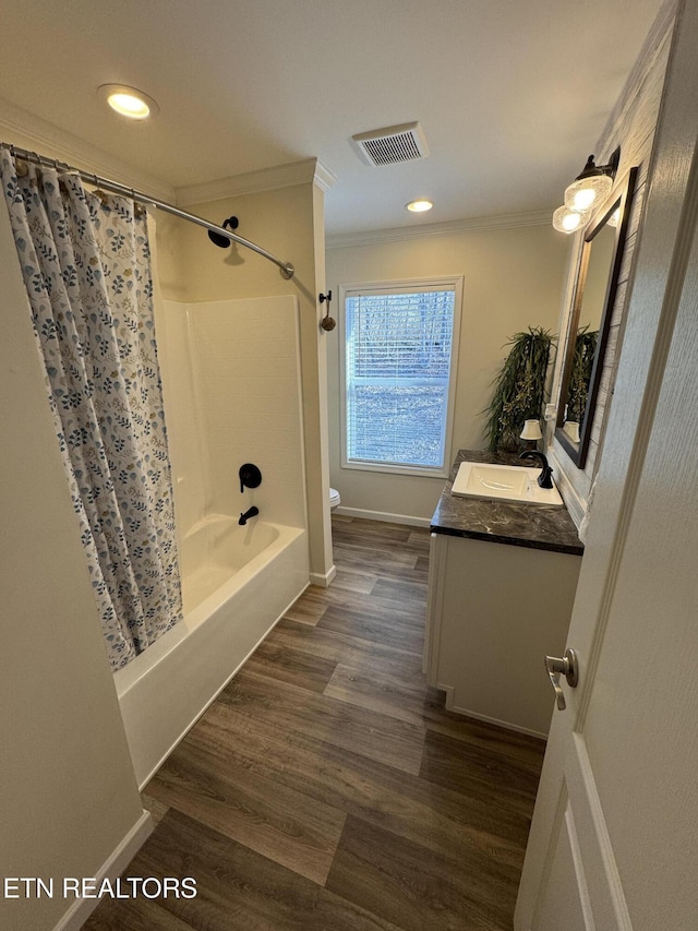 full bathroom featuring ornamental molding, vanity, shower / tub combo with curtain, hardwood / wood-style floors, and toilet