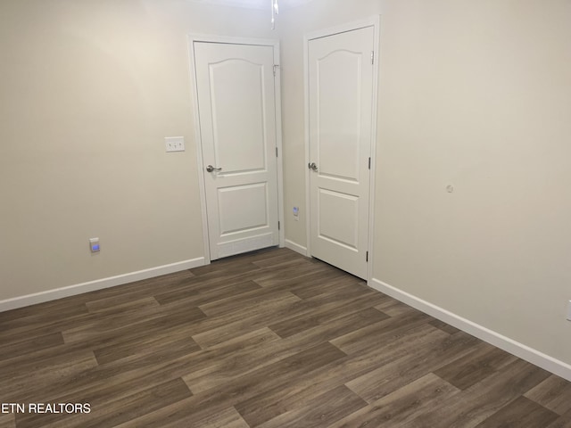 empty room with dark hardwood / wood-style flooring