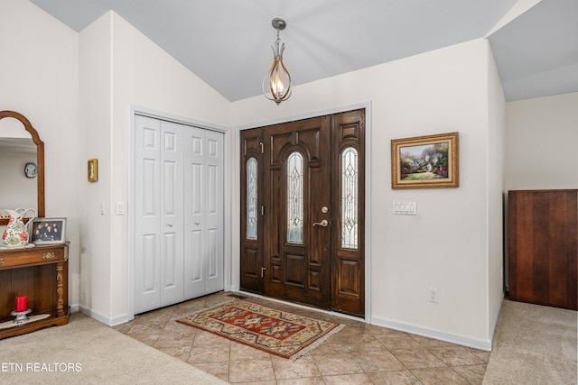 carpeted foyer entrance with vaulted ceiling