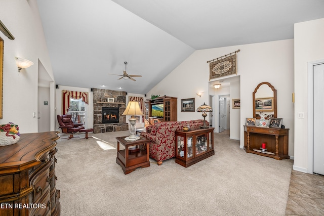 carpeted living room with vaulted ceiling, a stone fireplace, and ceiling fan