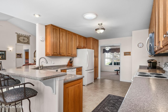 kitchen featuring ceiling fan, sink, a kitchen breakfast bar, kitchen peninsula, and white appliances