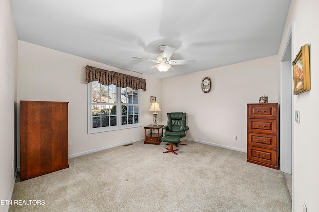 living area featuring ceiling fan and light colored carpet