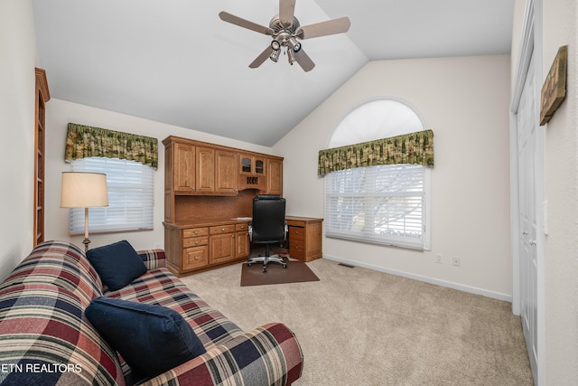 home office featuring light carpet, vaulted ceiling, and ceiling fan