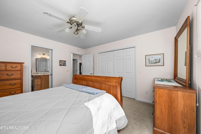 bedroom with ceiling fan, a closet, ensuite bathroom, and light carpet