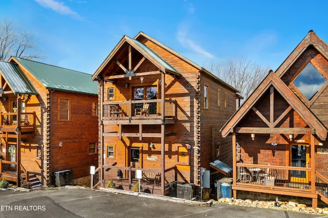 view of front of property with a balcony and central AC unit