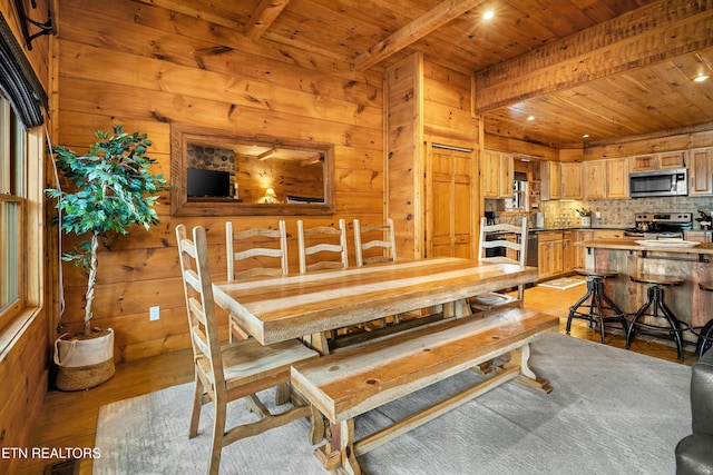 dining space with beamed ceiling, wooden ceiling, and light wood-type flooring