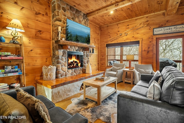 living room featuring wooden ceiling, beamed ceiling, wood walls, a fireplace, and hardwood / wood-style flooring