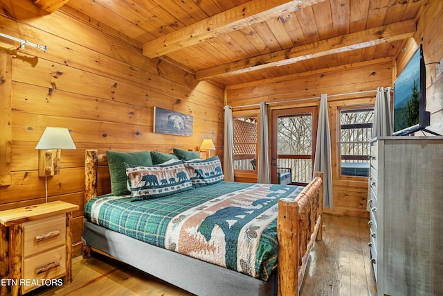 bedroom featuring hardwood / wood-style floors, wood walls, wooden ceiling, and beam ceiling