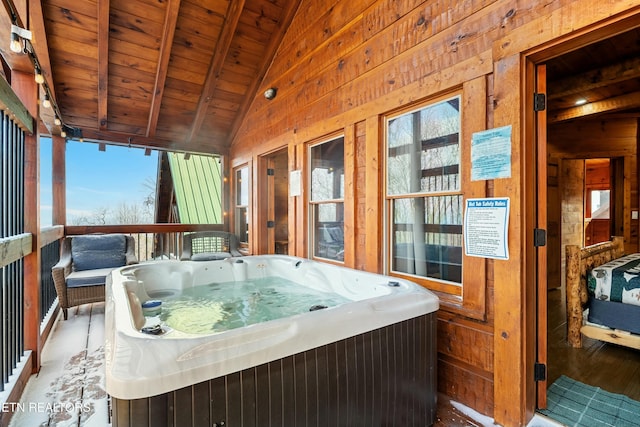 sunroom featuring a jacuzzi, vaulted ceiling with beams, plenty of natural light, and wooden ceiling