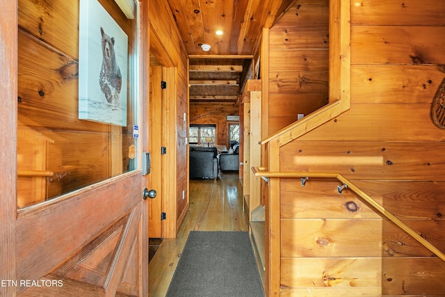 corridor featuring wooden walls, wood ceiling, and dark hardwood / wood-style floors