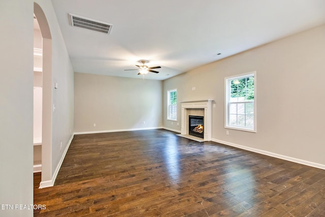 unfurnished living room featuring ceiling fan, dark hardwood / wood-style flooring, and a fireplace