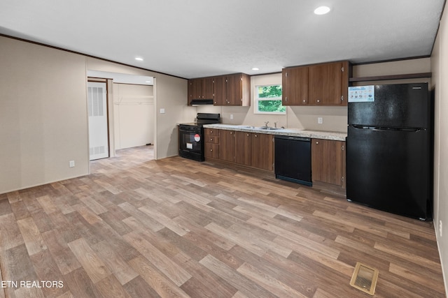 kitchen featuring sink, light wood-type flooring, extractor fan, and black appliances