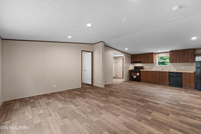 kitchen with black appliances, light wood-type flooring, ornamental molding, and a textured ceiling