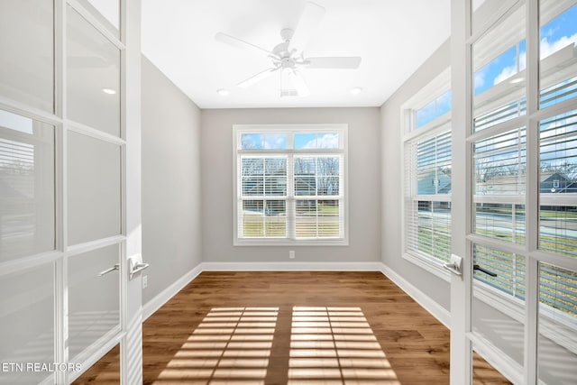 unfurnished sunroom featuring ceiling fan