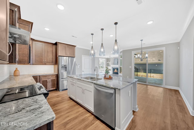 kitchen featuring a kitchen island with sink, white cabinetry, hanging light fixtures, and appliances with stainless steel finishes