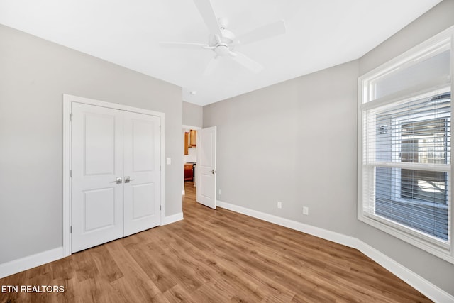 unfurnished bedroom featuring hardwood / wood-style flooring, ceiling fan, and a closet