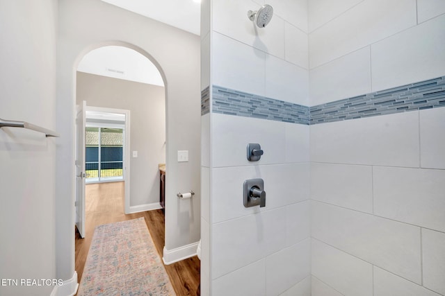 bathroom featuring wood-type flooring and tiled shower