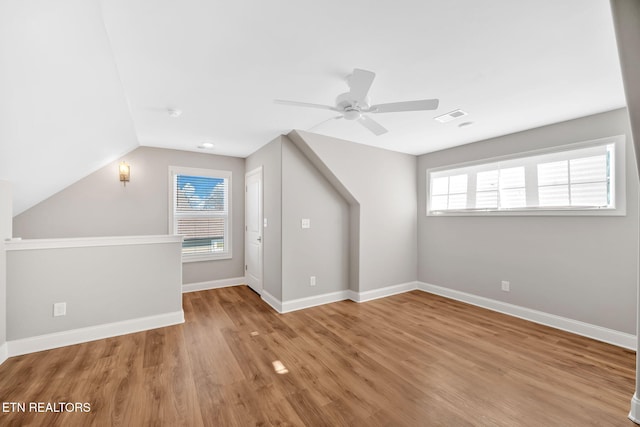 additional living space featuring ceiling fan, light wood-type flooring, and vaulted ceiling