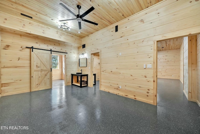 interior space featuring a barn door, wooden ceiling, and wooden walls