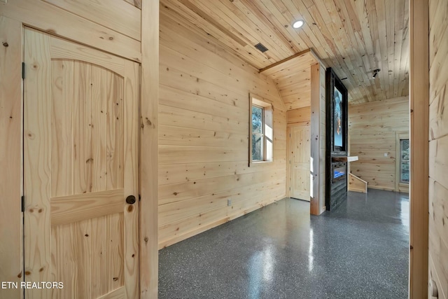 additional living space featuring wooden ceiling and wooden walls