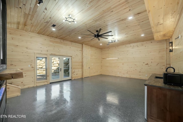 unfurnished living room featuring french doors, a towering ceiling, wood ceiling, ceiling fan, and wood walls