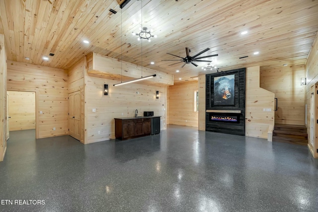 unfurnished living room with a large fireplace, wooden ceiling, and wooden walls