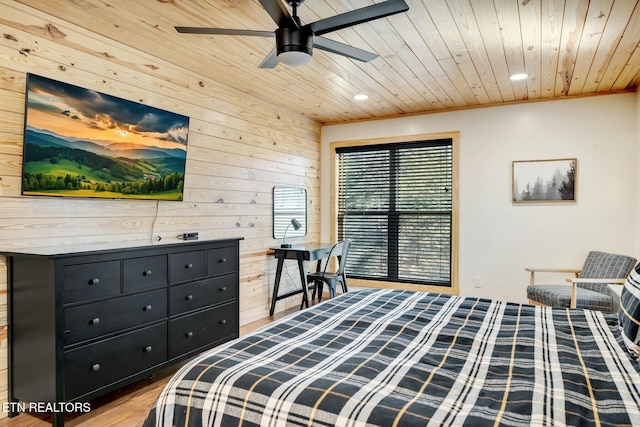 bedroom with light wood-type flooring, ornamental molding, wood ceiling, ceiling fan, and wood walls