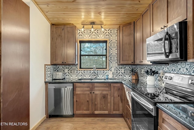 kitchen with sink, wooden ceiling, backsplash, dark stone countertops, and appliances with stainless steel finishes