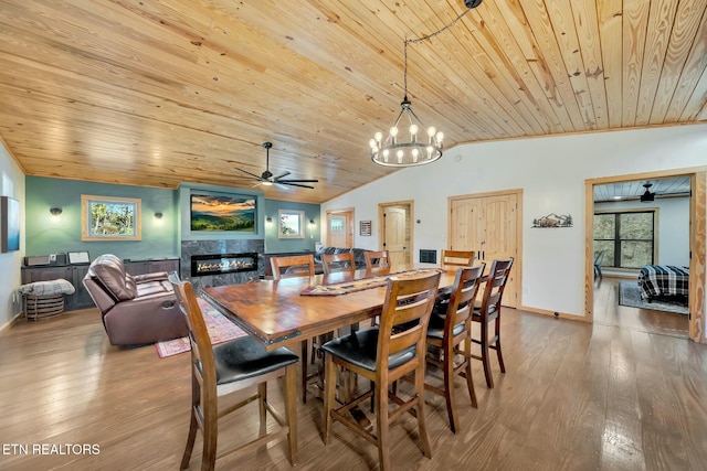 dining area with hardwood / wood-style floors, ceiling fan with notable chandelier, wooden ceiling, and vaulted ceiling