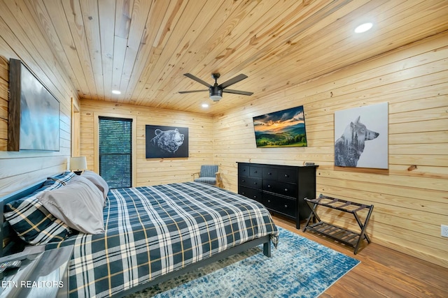 bedroom featuring ceiling fan, wood walls, wood-type flooring, and wood ceiling