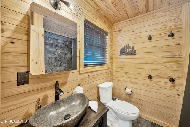 bathroom with vanity, toilet, wood ceiling, and wood walls