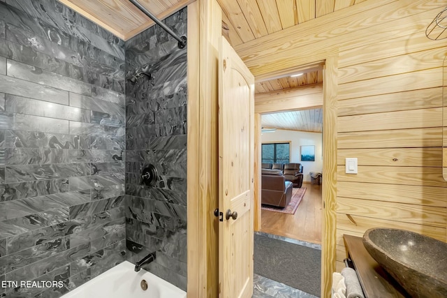 bathroom with tub / shower combination, wooden walls, vaulted ceiling, and wooden ceiling