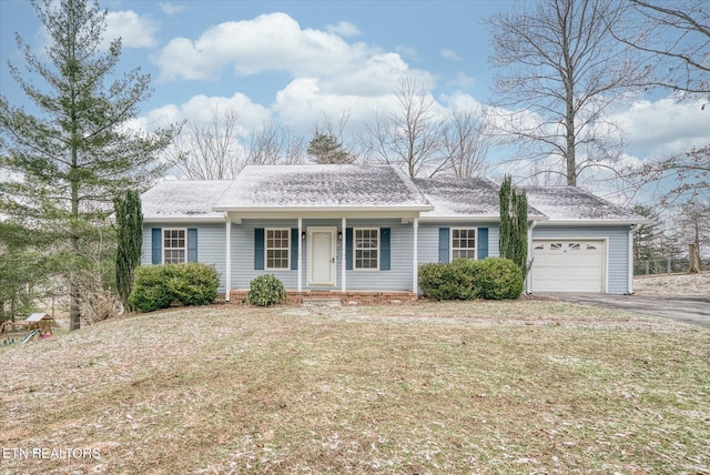 ranch-style home with a garage and a front lawn