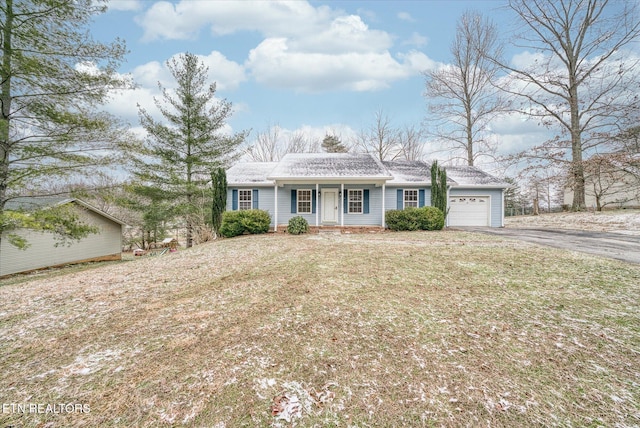 ranch-style home featuring a front yard, a garage, and covered porch