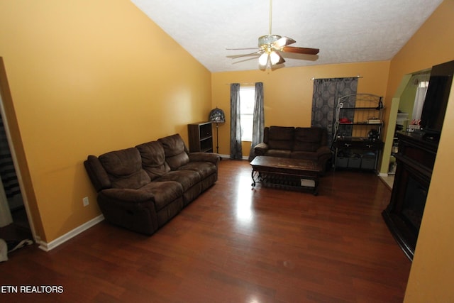 living room with a textured ceiling, ceiling fan, dark hardwood / wood-style flooring, and vaulted ceiling