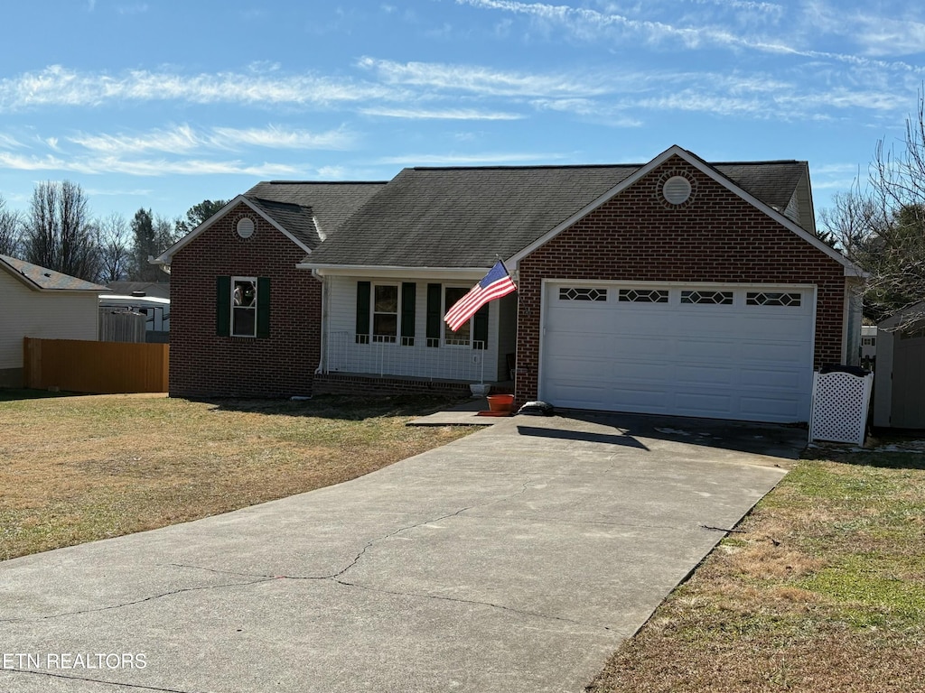 single story home featuring a front lawn and a garage