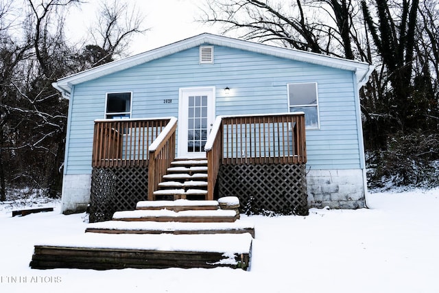 snow covered rear of property featuring a wooden deck