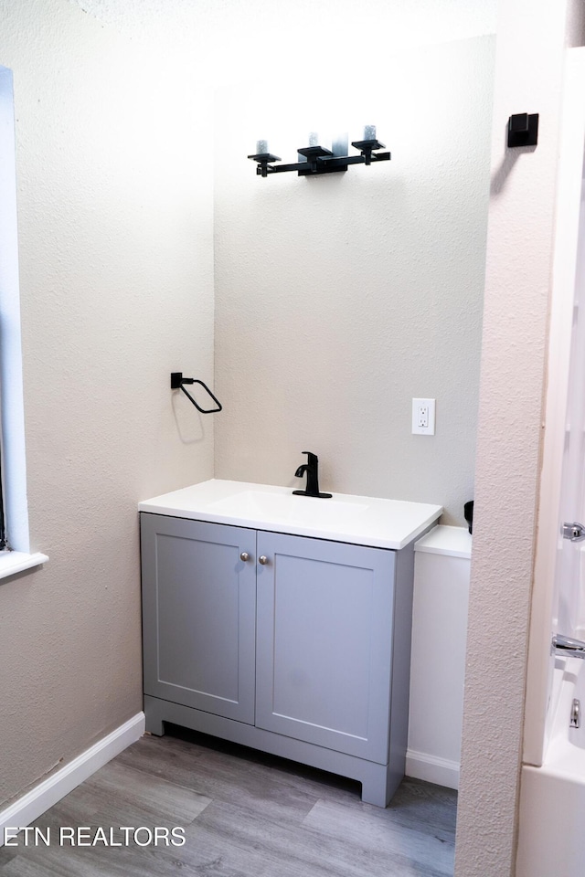 bathroom featuring hardwood / wood-style flooring, vanity, and shower / washtub combination